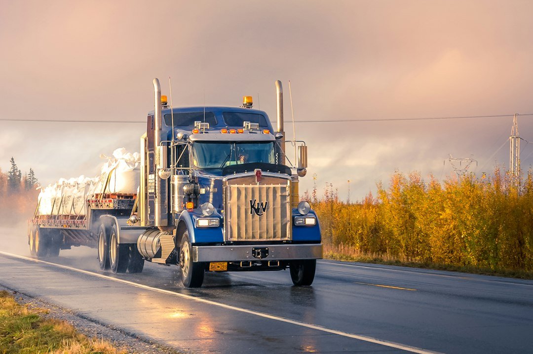 Semi truck driving on a highway, representing owner-operator rate-per-mile decisions