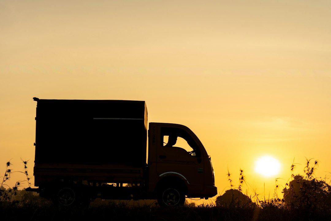 Semi truck driving on a highway at sunset, representing loaded and deadhead miles